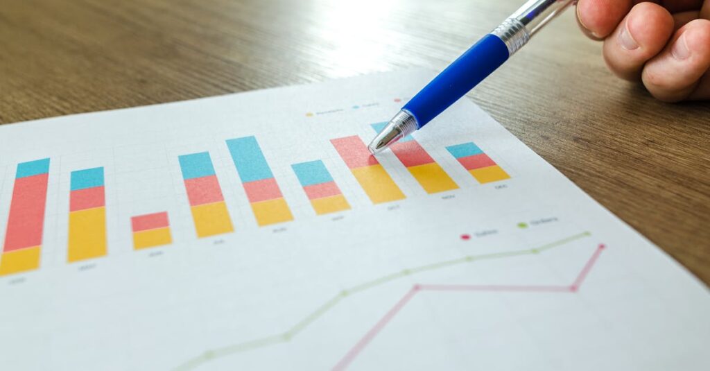 imagem de mão de uma pessoa segurando uma caneta e apontando para um papel onde se vê um gráfico de resultados de marketing, em artigo de blog sobre linkedin para empresas